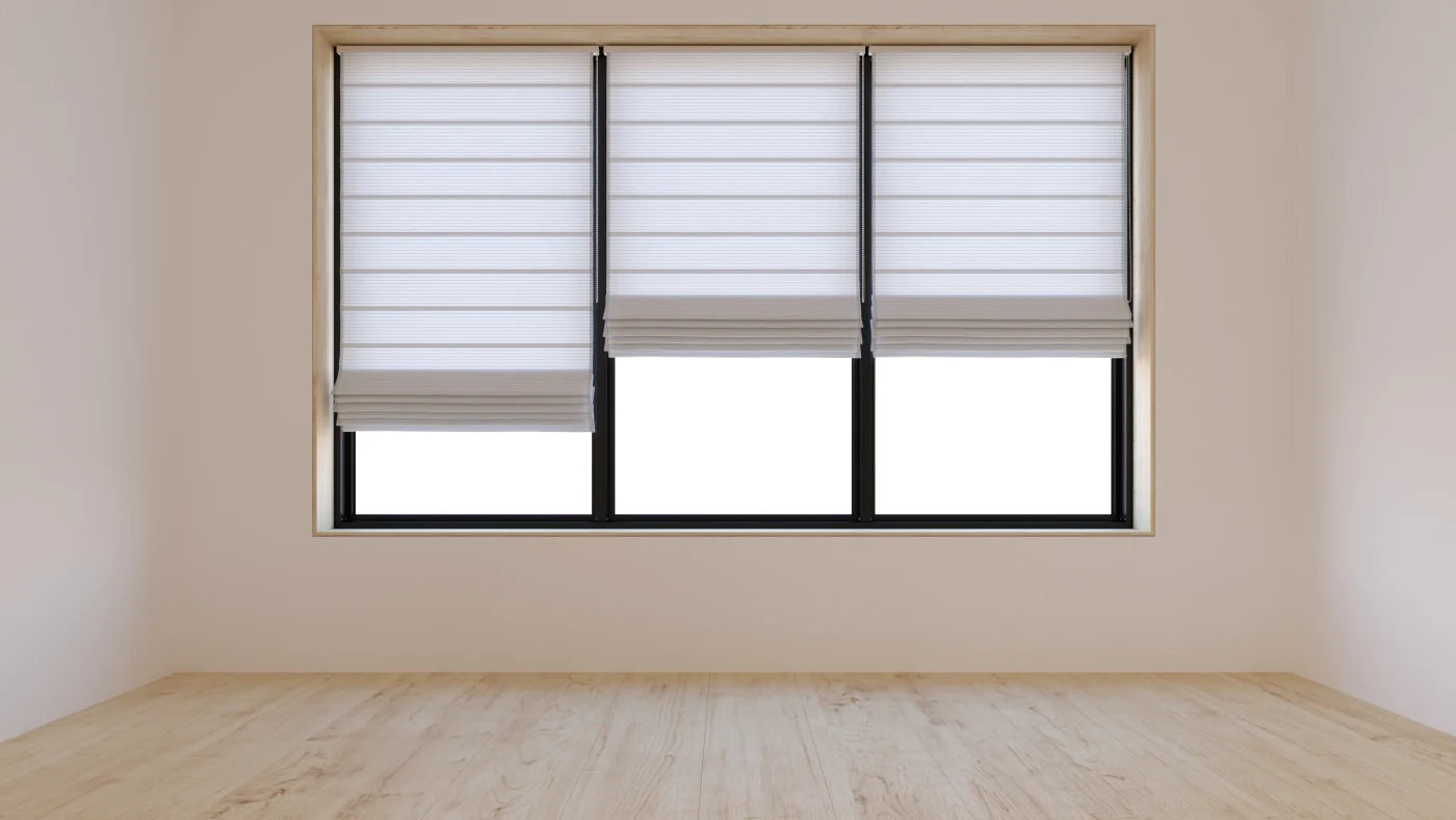A wide rectangular window with three sections of glass. The window frame is black, and all three sections have partially lowered, light-colored Roman shades. The walls are painted pale tan, and the floor is light colored wood.