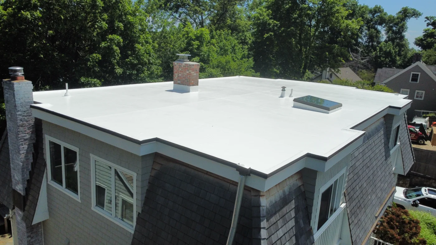 A flat commercial roof on a building fitted with a new flat roof system by a roofing crew.