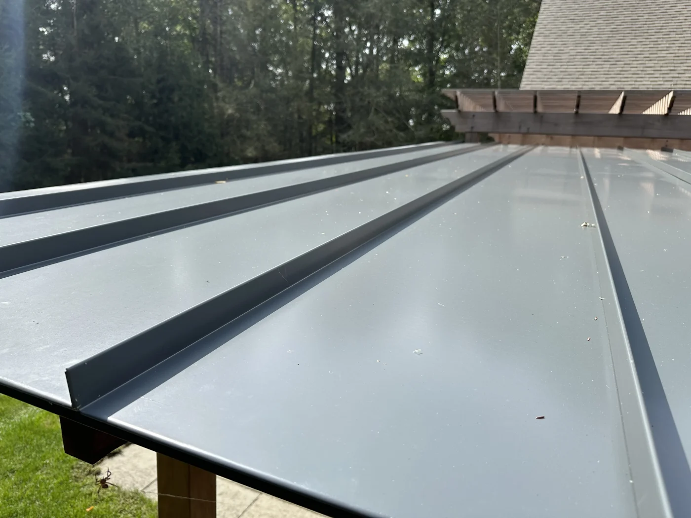 A dark, slate gray standing seam metal roofing up-close.