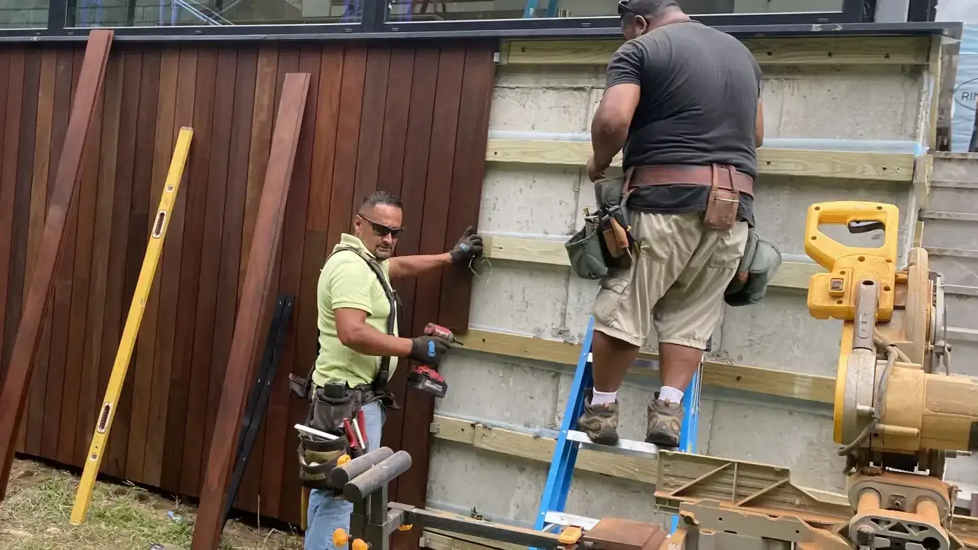 A view of two Sound Renovation siding pros installing cedar boards on a local home.