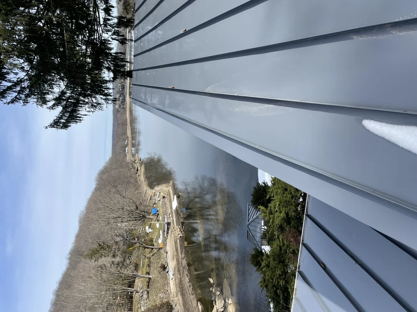 A close-up view of a dark metal roof installed on a home near the coast.