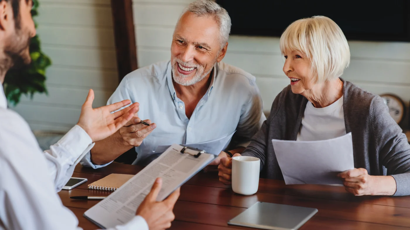 A close view of a smiling older couple getting advice on their project.