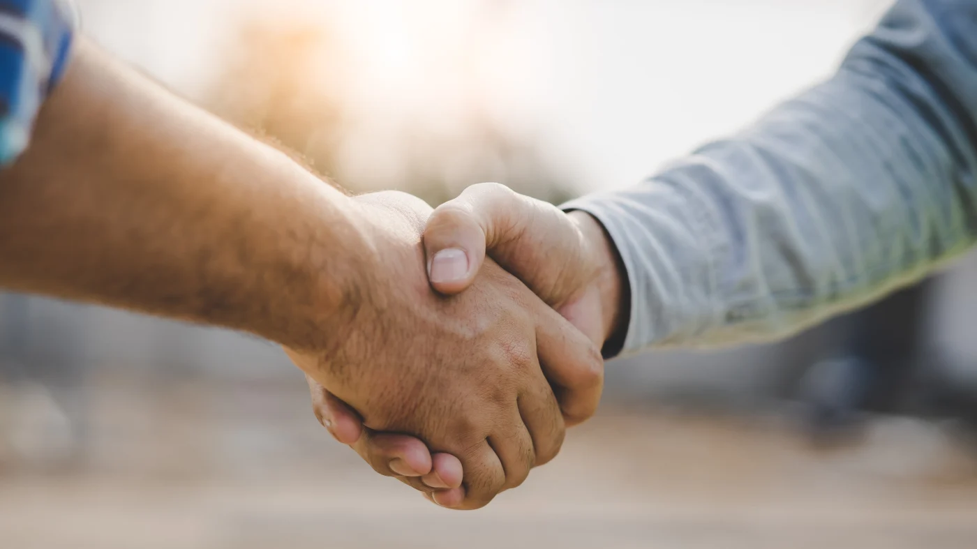 Integrity-First Exterior Services | Fairfield County, CT | Sound Renovation A close shot of two men shaking hands against a diffuse outdoor background.