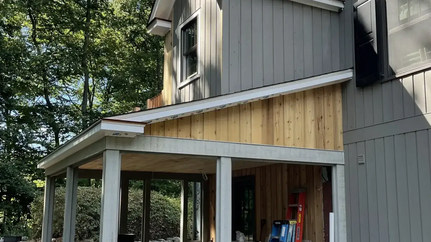 A close view of a new section of siding installed on a porch overhang.