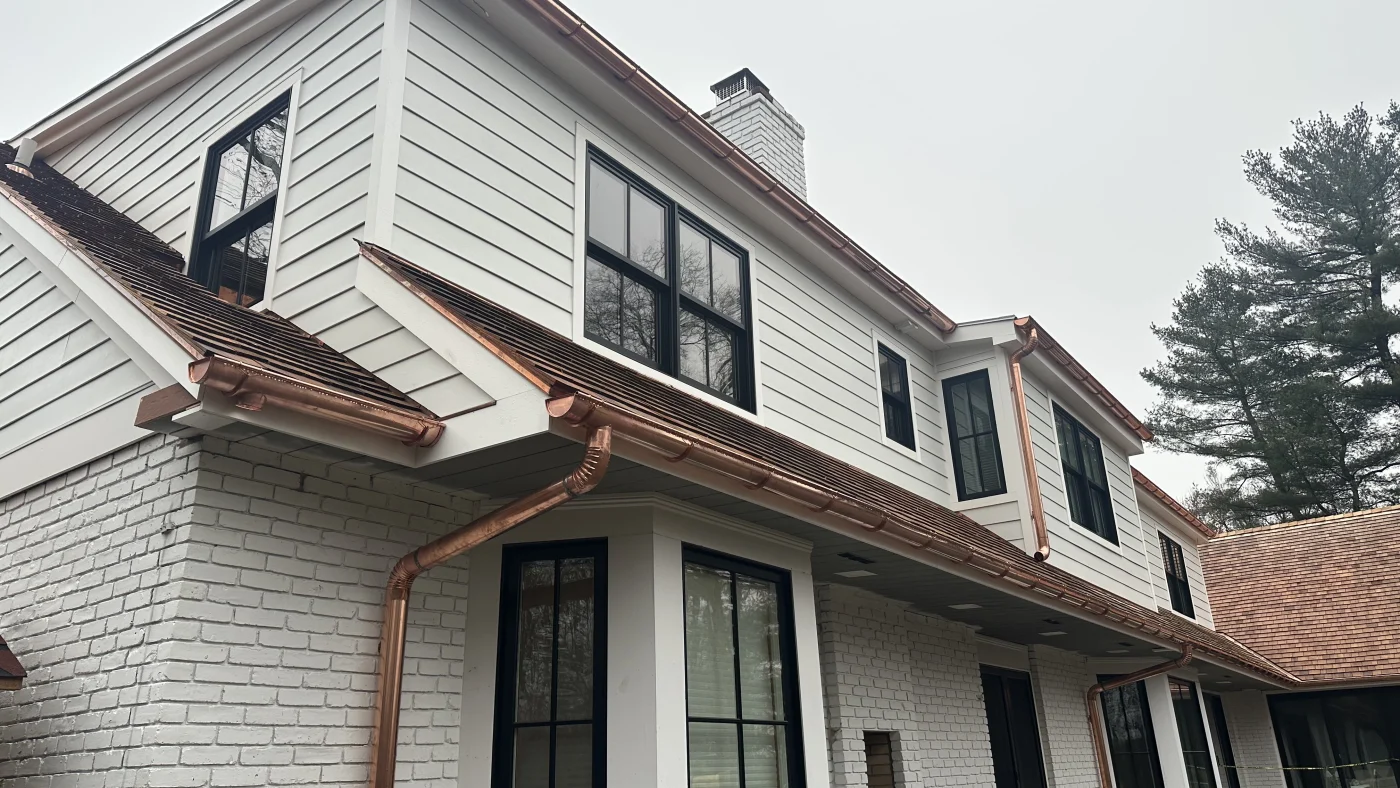 A wide view of the new copper gutters and downspouts installed on a local home.
