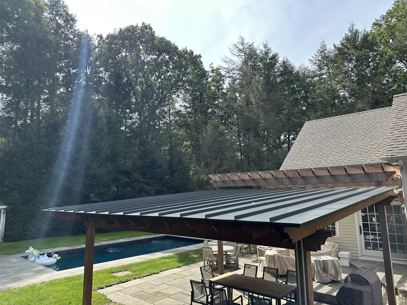 A black standing seam metal roof installed on an addition on a home.