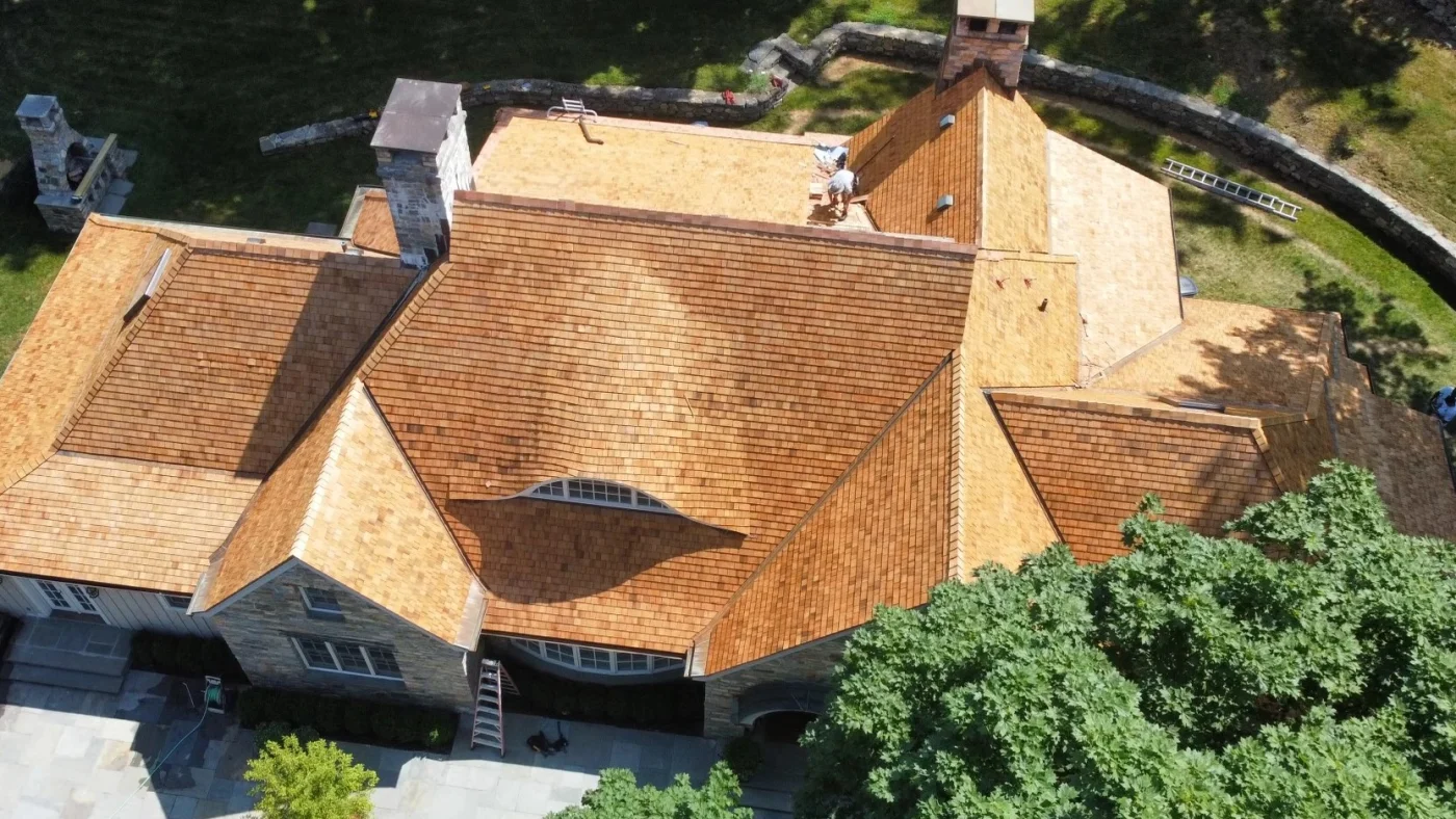 Top-Tier Roof Replacements | Fairfield County, CT | Sound Renovation An overhead view of an in-progress Sound Renovation cedar roof replacement on a huge local home.
