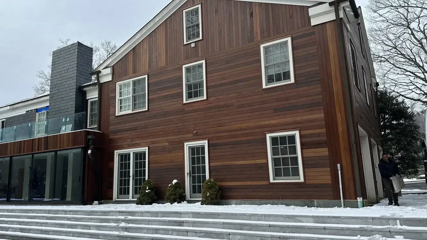 A wide shot of the new Maibec cedar siding installed on a large local home by Sound Renovation.