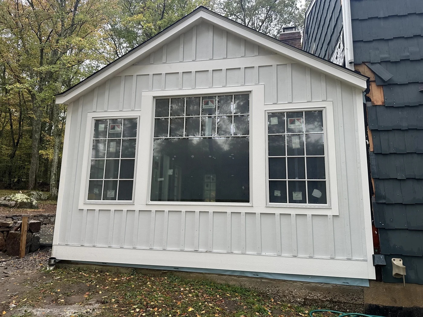 A row of new double-hung windows with clean white trim installed on the front of a home.