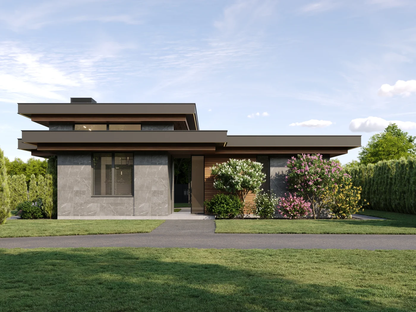 A zoomed-out shot of a modern home with a flat roof. The walls of the left side of the home are gray, and there’s a wooden accent wall to the right of the front door. The roof’s edges are dark colored with a brown underside. The yard is well cared for with bushes, trees, and bright green grass.
