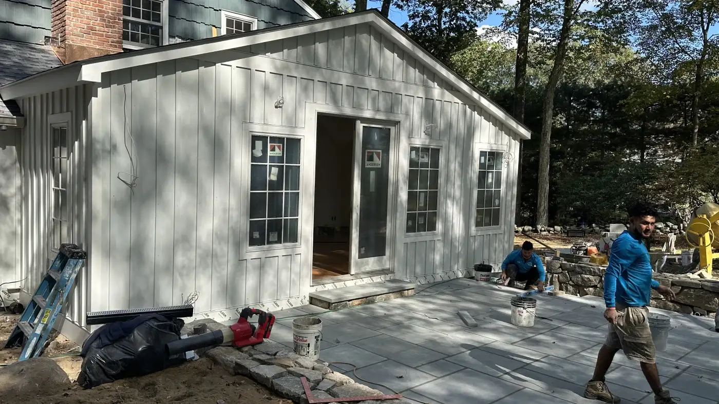 A wide shot of two Sound Renovation crew members working on the last stages of a siding project.